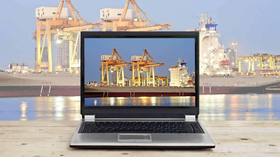 logistic business concept idea, laptop on wooden table with port warehouse and cargo ship background